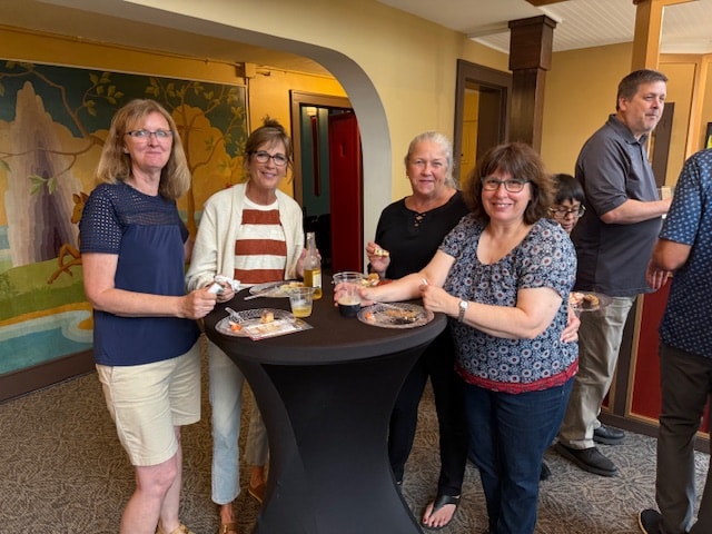 Annual meeting guests socializing around a cocktail table