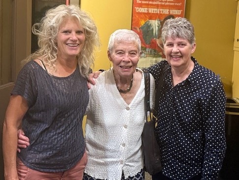 Three women posing together at the annual meeting