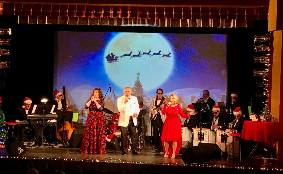 Holiday concert performers on a decorated stage