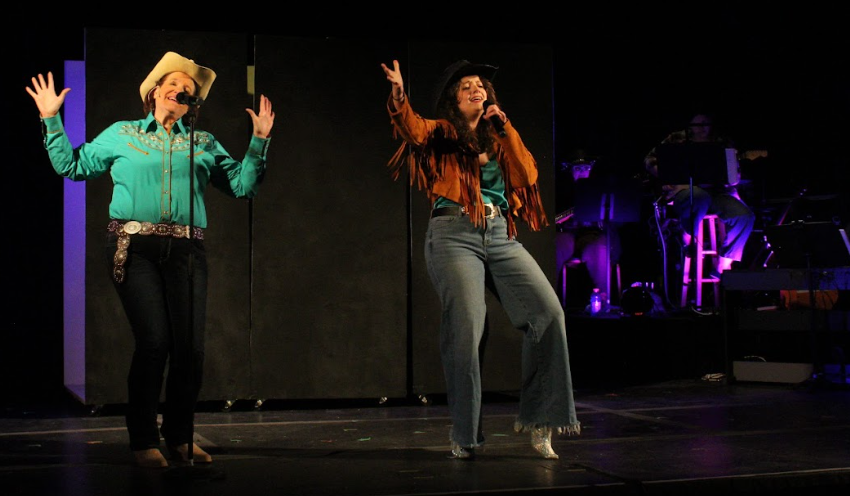 Two singers performing live on stage