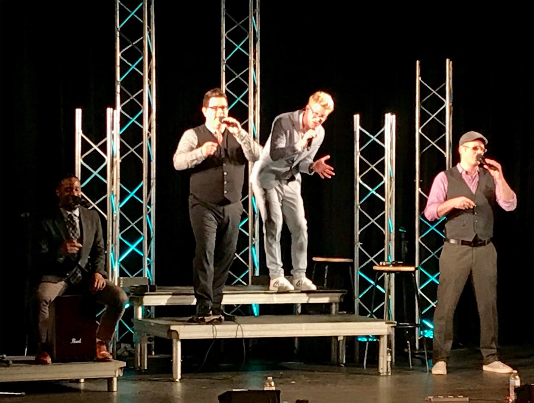 Vocal ensemble performing on stage under theatre lights