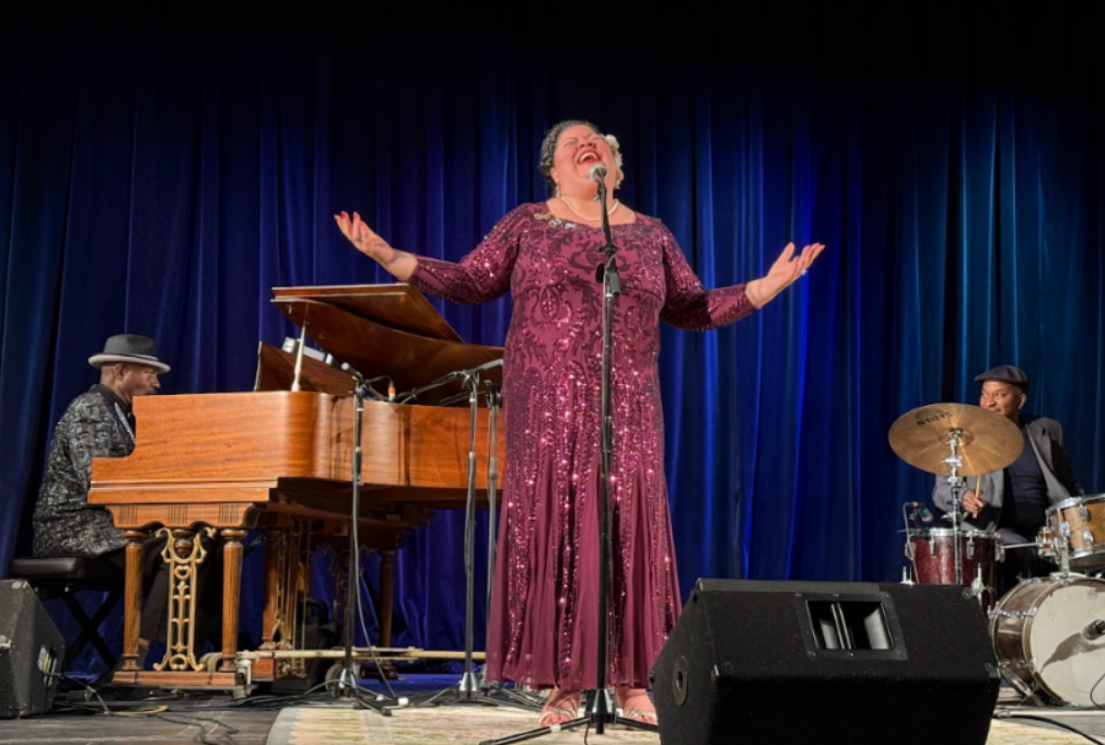 Vocalist performing with piano and drums on the theatre stage