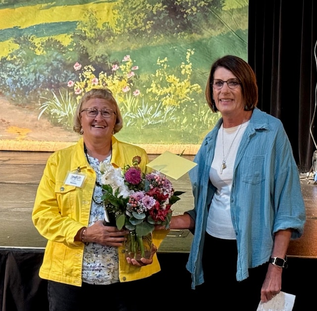 Volunteer of the Year honoree receiving a bouquet on stage